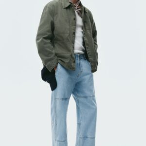 Les pantalons carpenter en denim délavé clair présentent des empiècements visibles au niveau des genoux et du haut des cuisses, avec des surpiqûres contrastées sur l'ensemble. Ils affichent une coupe droite décontractée, vue de face.